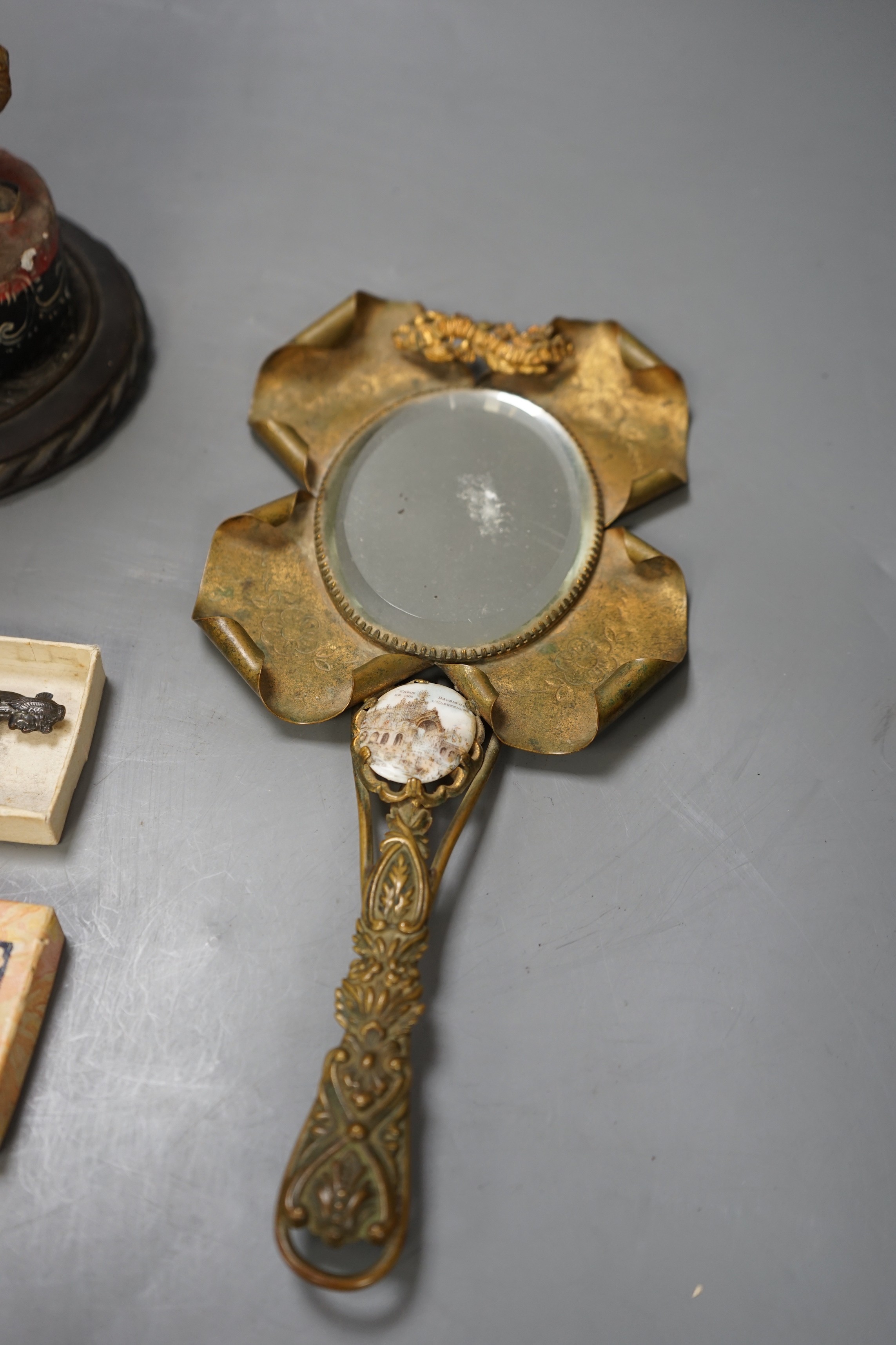 An Oriental carved painted wooden figure, together with an early 20th century 'Chicago World Fair' bottle opener souvenir, and a 1900 Paris exposition mirror with floral and scroll motif (3)